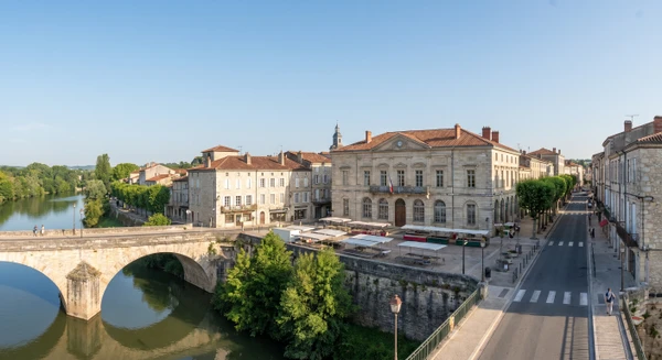 Vue panoramique ou photographie urbaine de Villeneuve-sur-Lot montrant des bâtiments résidentiels typiques de la région, avec architecture locale caractéristique, rue principale ou quartier résidentiel. Image claire, professionnelle, sous bon éclairage naturel, sans personnes au premier plan, illustrant le cadre géographique et urbain de la zone d'intervention de l'entreprise.