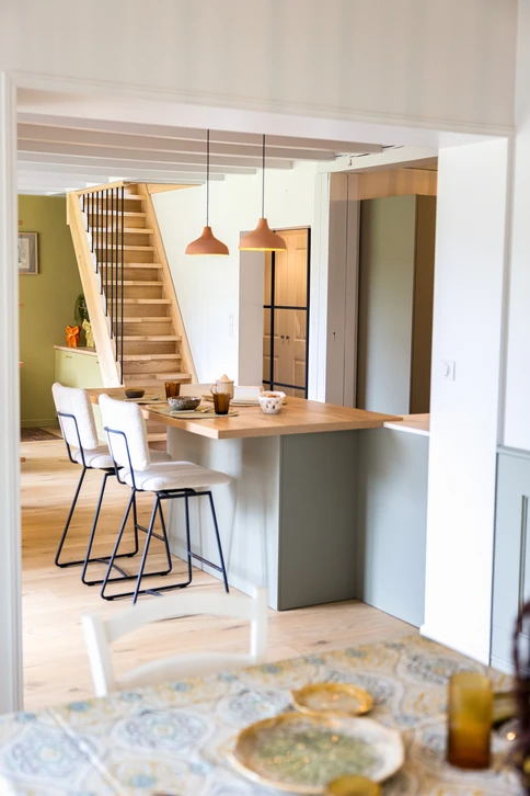 Intérieur de maison en construction avec cheminée moderne encastrée, murs en plaques de plâtre non peints, plafond à caissons avec poutres apparentes blanches